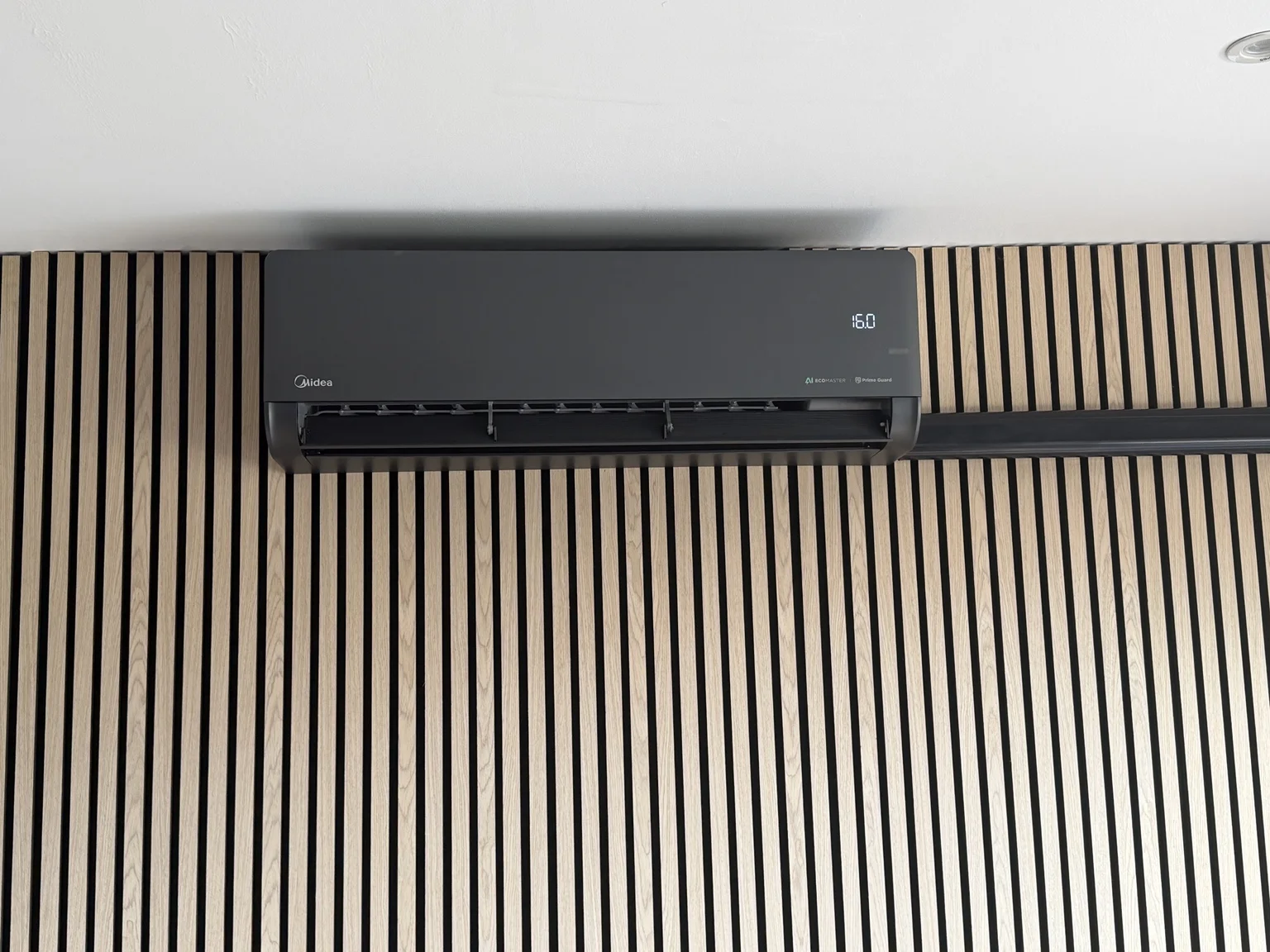 Black Midea air conditioning unit installed by KHM on a timber feature wall
